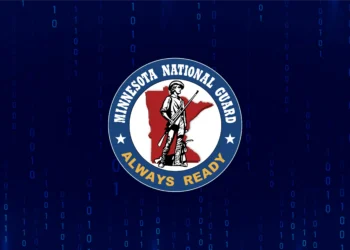 Minnesota National Guard seal over a digital binary background, representing the Guard's cyber protection deployment to Winona County following the April 2026 cyberattack.